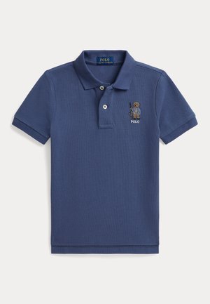 Μπλε polo με κοντά μανίκια, δύο κουμπιά και κεντημένο αρκουδάκι Polo που κρατά εξοπλισμό ψαρέματος στο αριστερό μέρος του στήθους.