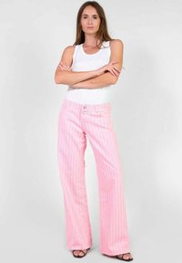 Roze gestreepte brede pijpen met een hoge taille, met twee knopen en een zachte textuur. Combinatie met een wit mouwloos topje.