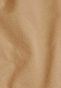 Tessuto color ocra con una superficie liscia e un leggero lucido. Presenta un fine motivo a coste su tutta la superficie. Adatto per rivestimenti o abbigliamento.