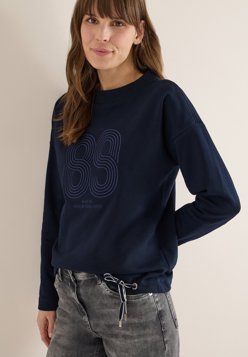 Marineblaue Sweatshirt mit rundem Ausschnitt, langen Ärmeln und gerippten Bündchen. Mit blauem Grafikdesign auf der Vorderseite und einem Tunnelzug am Saum.