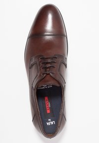 Chaussure habillée en cuir marron avec une finition polie, un bout pointu et un design traditionnel à lacets. Présente des coutures contrastantes et une semelle intérieure rembourrée.