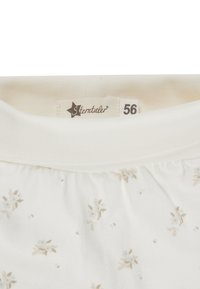 Weißes Babybekleidungsstück mit beigem Blumenmuster, elastischem geripptem Bund und Markenlabel von Stemtaler in der Größe 56.