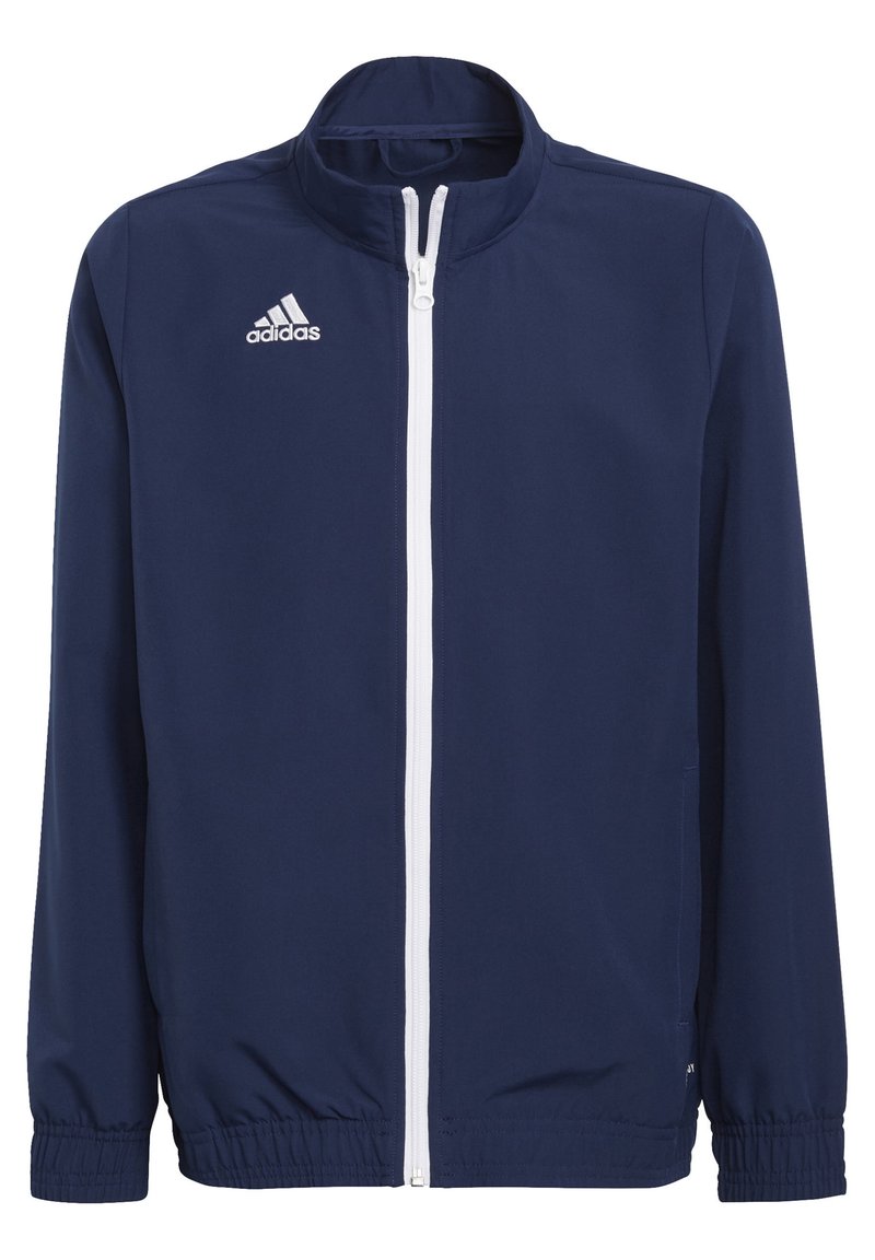 Navyblauwe jas met een hoge kraag, witte rits en elastische mouwen. Voorzien van het Adidas-logo in het wit geborduurd op de linkerkant van de borst.