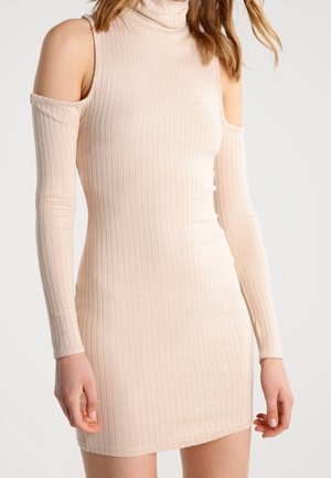 Robe en maille côtelée beige avec manches longues, épaules dénudées et col roulé haut.