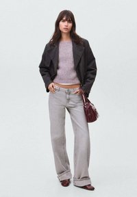 Siva prevelika denim jakna preko svetlo vijoličaste pletene dukserice, uparen s svetlo sivim širokim farmerkama i bordo torbicom.