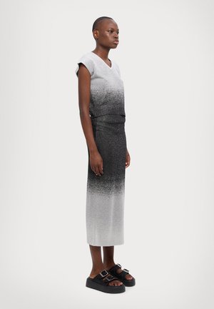 Gray and black ombré dress with short sleeves and a V-neck, made of soft material. Paired with chunky black sandals featuring dual buckles.