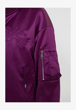 Paarse satijnen bomberjack met geborduurd logo, één met rits sluitend mouwvak en een patch pocket, met een soepele textuur en een ontspannen pasvorm.