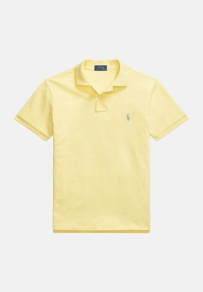 Polo giallo con colletto classico, maniche corte e un sottile logo ricamato in blu sul lato sinistro del petto. Materiale in cotone, texture liscia.