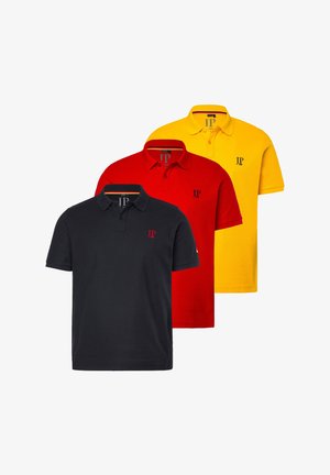 Tre foldede polo skjorter i sort, rød og gul, hver med et lille "JP 1880" logo på brystet.