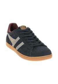 Sneakers in suede navy con strisce grigie, dettagli marroni e suola in gomma color caramello. Presentano un design con lacci e un logo dorato sulla linguetta.