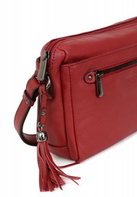 Borsa a tracolla in pelle rossa con chiusura superiore con zip, frangia decorativa, tasca anteriore con zip e hardware in tono argento. Texture liscia; forma rettangolare.