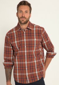 Czerwona i niebieska koszula w kratkę z kołnierzykiem na guziki, długie rękawy podwinięte do łokci, z białymi akcentami i dwoma kieszeniami na piersiach.