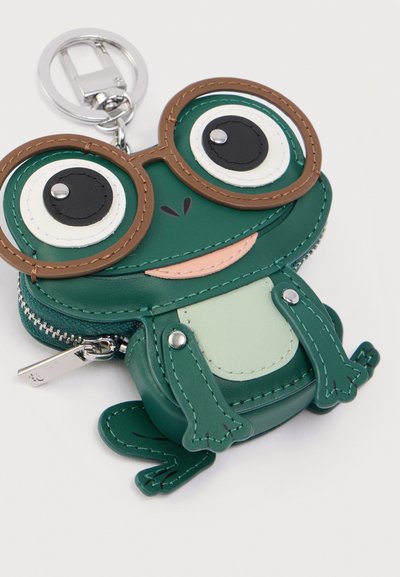 Πράσινη θήκη μπρελόκ σε σχήμα βατράχου από δέρμα, με μεγάλα μάτια, στρογγυλά καφέ γυαλιά και φερμουάρ για αποθήκευση.
