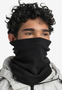 Gaiter de cuello de forro polar negro, diseño de alto cuello, textura suave, con acabado sin costuras y acento de logo. Usado sobre una chaqueta.