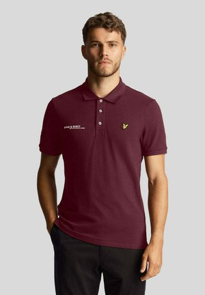 Polo shirt bordeaux realizzato in cotone con colletto, patta con tre bottoni, logo ricamato sul petto e maniche corte.