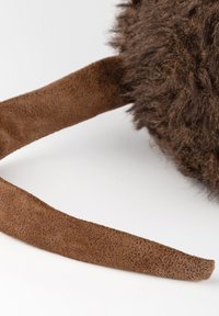 Brown fur pouch with a textured surface, featuring a flat brown suede strap. The design is round with soft, fluffy material.