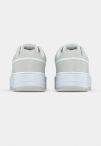 Λευκά αθλητικά παπούτσια με λείο επάνω μέρος από δέρμα, απαλές γκρι λεπτομέρειες, μαλακό κολάρο και λαστιχένια εξωτερική σόλα με υφή για καλύτερη πρόσφυση.