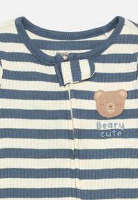 Tutina per neonati a righe blu e bianche con chiusura a scatto e testa di orso marrone ricamata con il testo "Beary cute" sul petto.