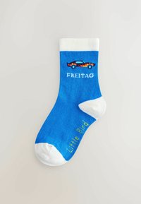Calzino di cotone blu con bordo bianco, caratterizzato da una grafica di un'auto decorata con fiamme e il testo "FREITAG" sopra e "Little Bird" in giallo sotto.