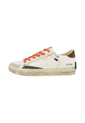 Sneaker bianca bassa con lacci arancioni, toppa marrone sul tallone, dettagli grafici neri e suola laterale bianco sporco leggermente usurata.
