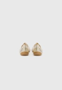 Vista posteriore di scarpe slip-on beige realizzate in materiale liscio con suole in gomma color tan; presentano un piccolo tallone e un design elegante e minimalista.