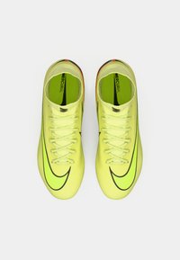 Un par de botas de fútbol Nike Mercurial en amarillo neón con logotipos de swoosh negros, vistas desde arriba sobre un fondo blanco.