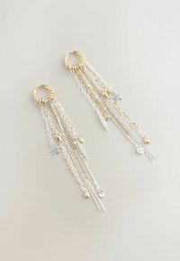 Uhani z zlatimi obroči na vrhu, s padajočimi verigami v zlati in srebrni barvi, okrašeni z dekorativnimi čari, vključno z zvezdami in listi.