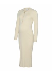 Stickad mammaklänning i kremfärg med ribbad textur, långa ärmar, knälång, med rund halsringning och tre guldknappar som detaljer.