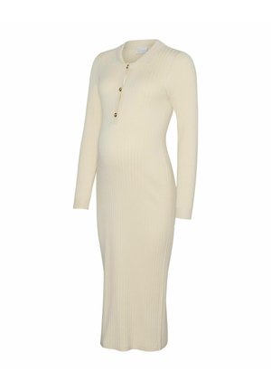 Strikket mamme-kjole i kremfarge med ribbet tekstur, lange ermer, knelang lengde, med rund halslinning og tre gylne knappe-detaljer.