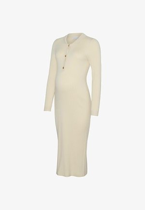 Strikket graviditetskjole i creme med ribbet tekstur, lange ærmer, knælængde, med rund halsudskæring og tre gyldne knapdetaljer.