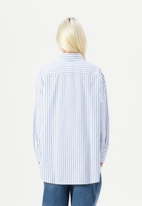 Blue and white striped long-sleeve shirt with a collar, featuring a relaxed fit and buttoned cuffs. The fabric appears smooth and lightweight.