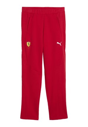 Røde atletikbukser med elastisk taljebånd, Ferrari-logo på venstre lår og hvidt Puma-logo på højre lår, forfra.