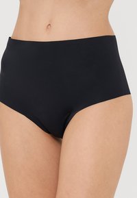 Magas derekú fekete bikini alsó sima, rugalmas anyagból készült. Letisztult, varrat nélküli dizájn jellemzi, látható díszítések nélkül.