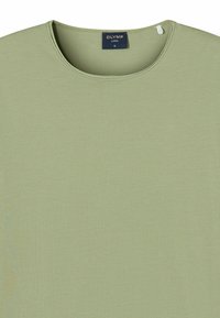 Hellgrünes lässiges T-Shirt mit rundem Ausschnitt, kurzen Ärmeln und glatter, weicher Textur; mit einem Etikett am Kragen versehen.