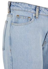Lys blå denim jeans har høy midje, fem lommer, synlig søm, og en metallglidelås med logo-merke.
