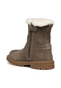 Bota de ante marrón hasta el tobillo con un cuello de piel sintética blanca, cremallera lateral y suela de goma texturizada. Presenta una etiqueta de "IMPERMEABLE" en el lateral.