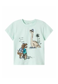 Mintgrünes Baumwoll-T-Shirt mit verspielten Dinosauriergrafiken, von denen einer ein Surfbrett hält und tropische Designelemente aufweist.