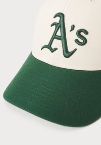 Baseball-lippalakki, jossa on vaalea yläosa ja vihreä lippa. Varustettu vihreällä brodeeratulla "A's"-logolla. Tasainen kangas ja jämäkkä muotoilu.