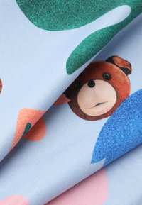 Textil cu un fundal albastru moale, decorat cu forme abstracte colorate. Include un design stilizat al unei urși brun. Textură asemănătoare catifelei.