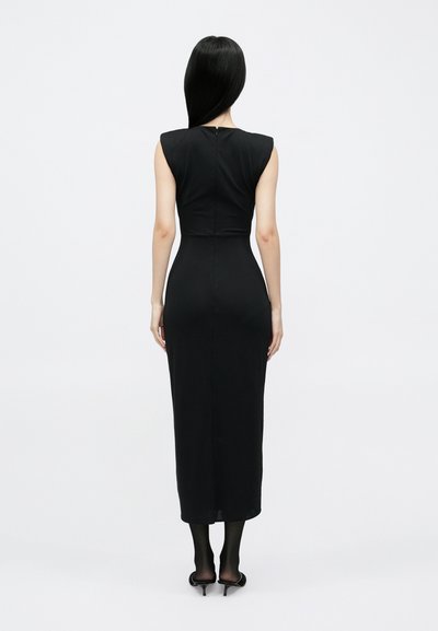 Fekete ujjatlan ruha, ráncolt felsőrésszel és hosszú, egyenes szoknyával. Az anyag simának tűnik, hátul cipzárral és térd alá érő szegéllyel.