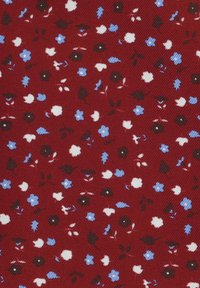 Czerwona tkanina z małym wzorem kwiatowym zawierającym białe, niebieskie i czarne kwiaty, z zielonymi liśćmi oraz teksturowanym wykończeniem.