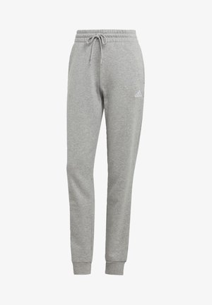 Jasnoszare spodnie dresowe Adidas z elastycznym pasem, sznurkiem, ściągaczami przy kostkach oraz małym białym logo Adidas na górnej lewej części uda.