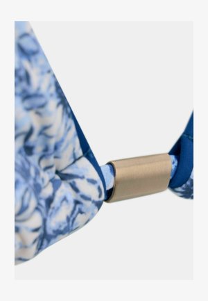 Tela con un patrón floral en tonos azules y un cierre metálico dorado, que presenta una textura suave y bordes lisos. El diseño combina vibrantes tonos azules.