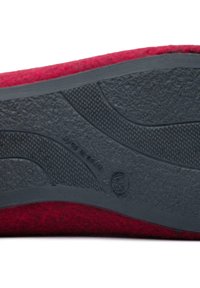 Red felt slipper with a black rubber sole, featuring a textured surface and a curved design. "Made in Spain" is embossed on the sole.