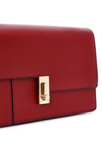 Borsa a mano rossa in pelle con una texture liscia, dotata di una chiusura color oro e cuciture nere lungo i bordi. Forma rettangolare.