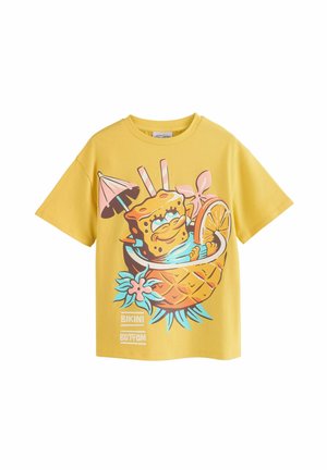 Gul bomull t-shirt med en grafisk design av en tecknad karaktär i en ananas, med livliga accenter och lekfulla detaljer.