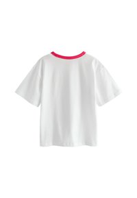 Bela majica s kratkimi rokavi, okrogli izrez s kontrastnim roza trakom. Mehki bombažni material, sproščen kroj, gladka tekstura.