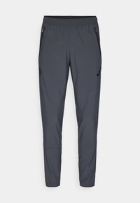 Pantalons de sport gris avec une taille élastique, poches latérales zippées et un détail de logo sur la cuisse gauche. Fabriqué en tissu léger.