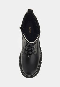 Stivale alla caviglia nero con tomaia in pelle liscia, punta rotonda, chiusura con lacci sul davanti e zip laterale. Presenta cuciture bianche e suola testurizzata.