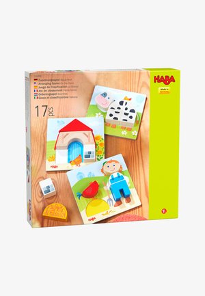 Holzpuzzles mit Bauernhofmotiven, die eine Kuh, einen Stall, einen Bauern, ein Huhn, Heu und einen Stein auf illustrierten Hintergründen zeigen.